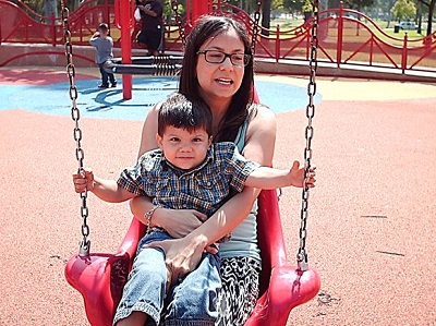 a Mom and her child on a swing at the sensory playground